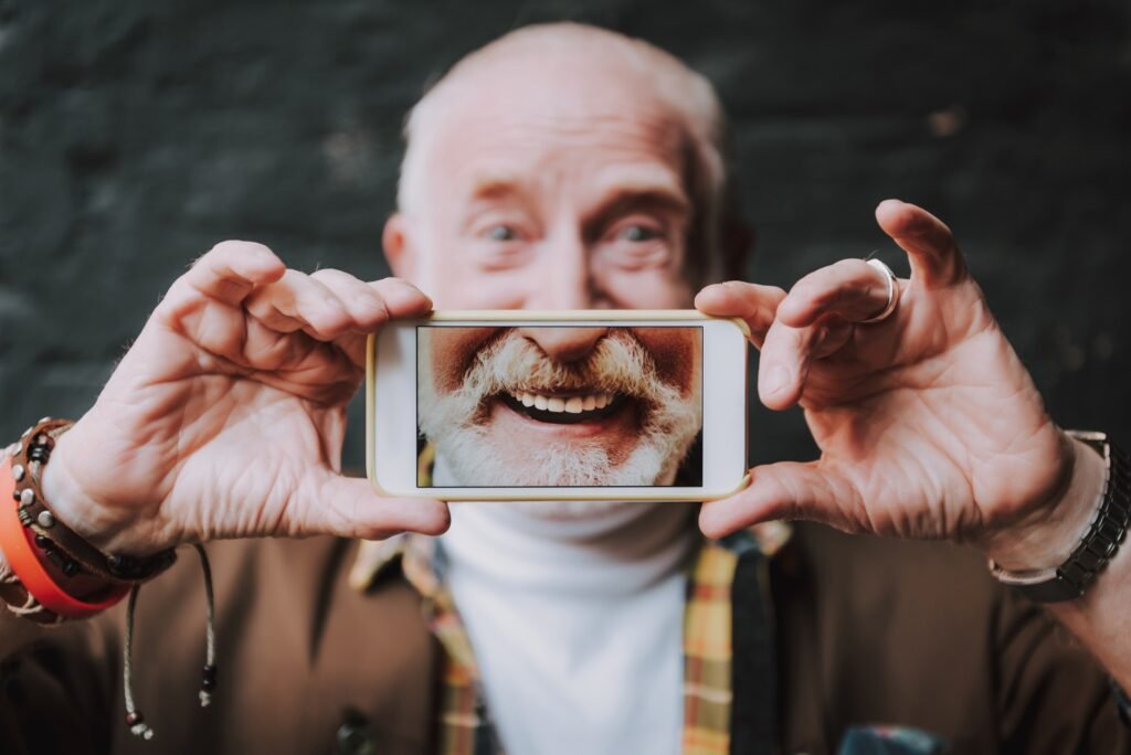 Stylowy starszy mężczyzna trzyma smartfona w rękach