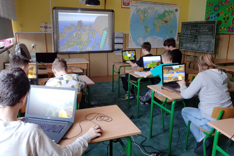 Zdjęcie przedstawia uczniów wykonujących zadanie w grze Minecraft